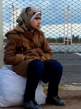 <p>Syrian woman awaits transport to a refugee camp in Turkey.</p>