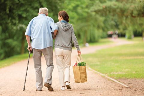 A photo of an older man with a cane walking with a younger woman to illustrate the article A Biblical Perspective on Caregiving