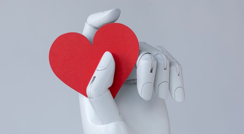 Graphic of a robot hand holding a red heart to illustrate the article