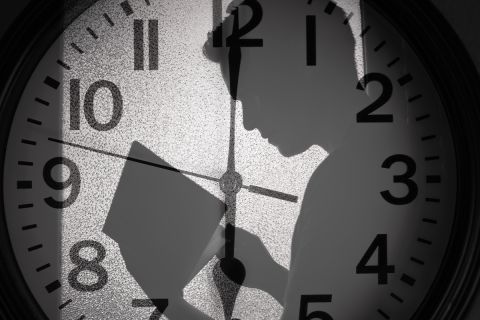 A man's shadow over a clockface to illustrate the article 