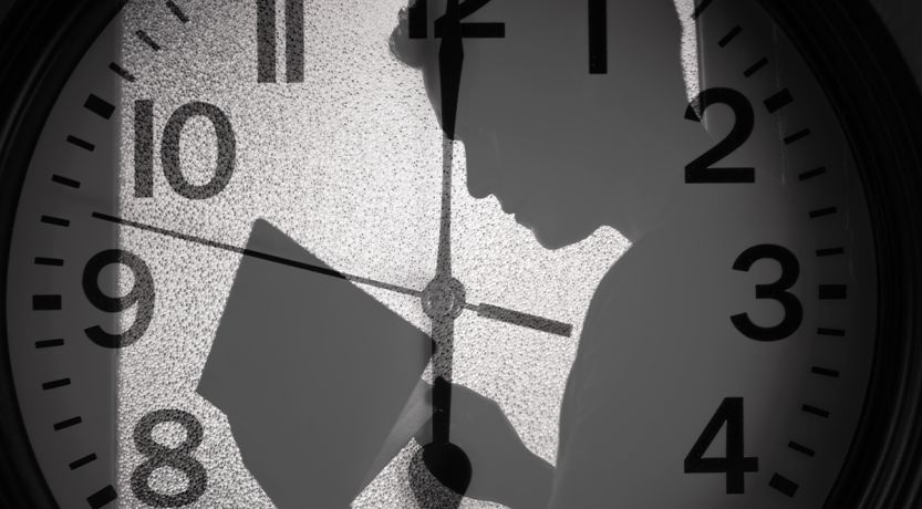 A man's shadow over a clockface to illustrate the article 