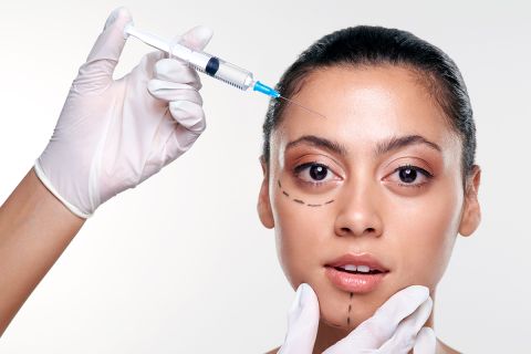 Photo of a young woman with face marked as if for cosmetic surgery, to illustrate the article 
