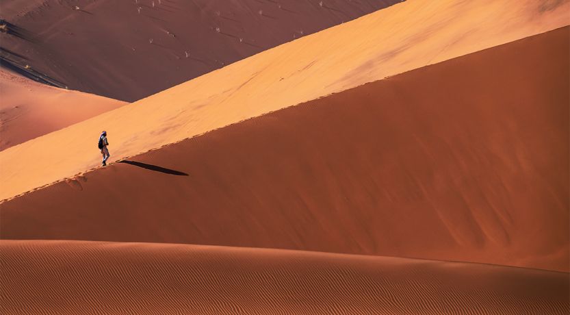 Graphic of a person on a distant sand dune to illustrate the article 