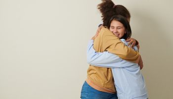 Photo of two friends hugging, to illustrate the article 