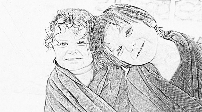 Black and white photo of two little girls with wet hair wrapped in towels to illustrate the article 