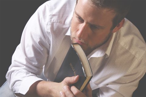Photo of a man holding a Bible with a serious expression on his face. This illustrates the article Does the Bible Make You Uncomfortable?