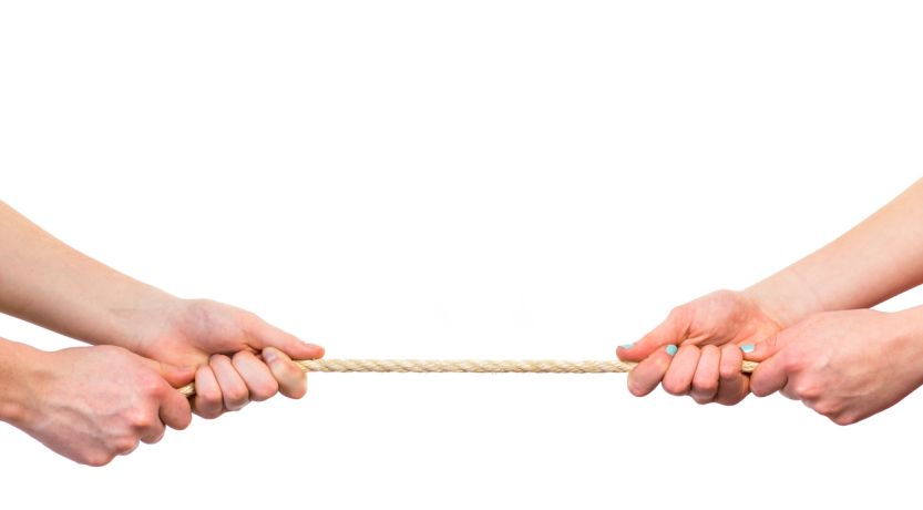 Photo of two people's arms tugging on a rope to illustrate the article Getting Past Adult Sibling Rivalry.