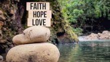 Photo of a sign on the shore of a lake with the words Faith, Hope, Love, to illustrate the article Hope and Faith in Action.