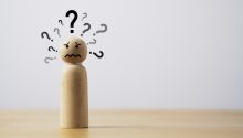 Graphic of a wooden figure with many question marks around his head to illustrate the article How Do You Handle Why?