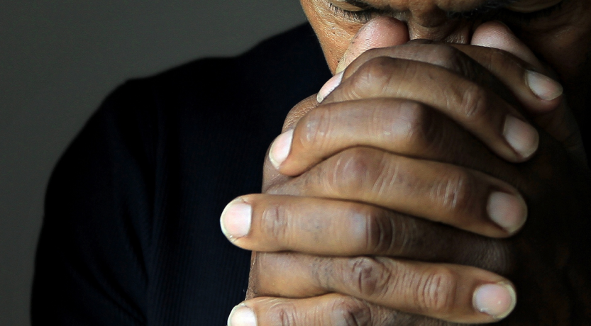 A man's clasped hands to illustrate Praying for Protection