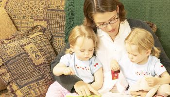 Reading for Ultimate Success; mom reading to two girls on her lap.