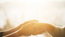 Photo of hands holding another's hand to illustrate the article 