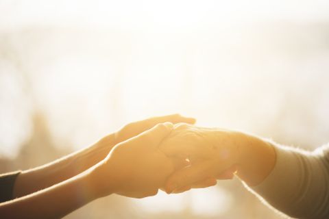 Photo of hands holding another's hand to illustrate the article 