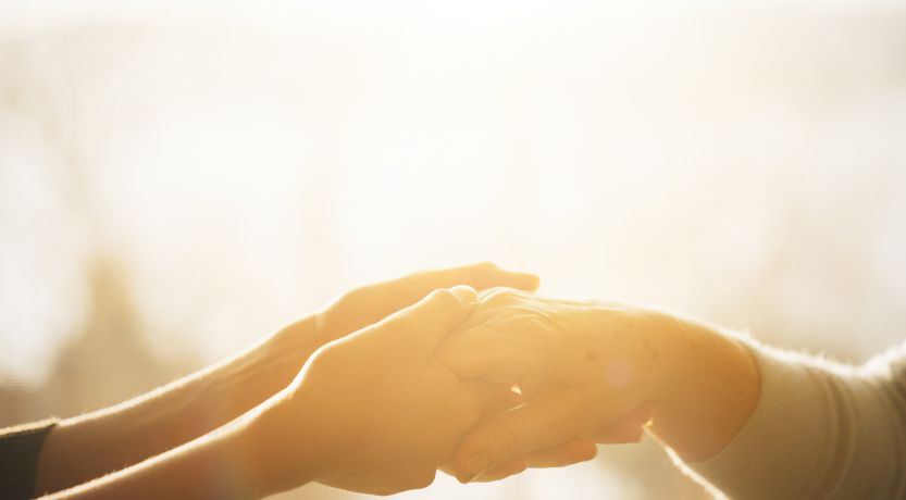 Photo of hands holding another's hand to illustrate the article 