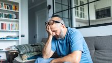 Photo of a man sitting with his face in his hand to illustrate the article 