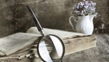 Photo of a magnifying glass leaning against a Bible to illustrate the article The Greatest Mystery of the Bible