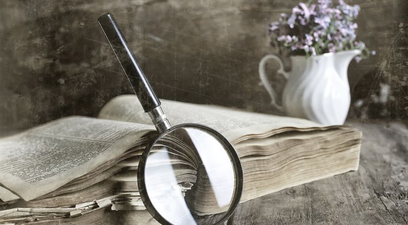 Photo of a magnifying glass leaning against a Bible to illustrate the article The Greatest Mystery of the Bible
