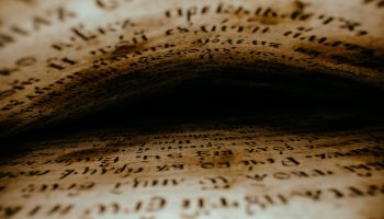 Graphic showing hard to read text above and below, as if between the pages of a book, fading to black in the center. This is to illustrate the article 