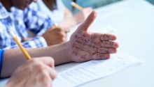 Photo of a test takers with cheat notes written on his hand, to illustrate the article What Does the Bible Say About Honesty and Integrity?