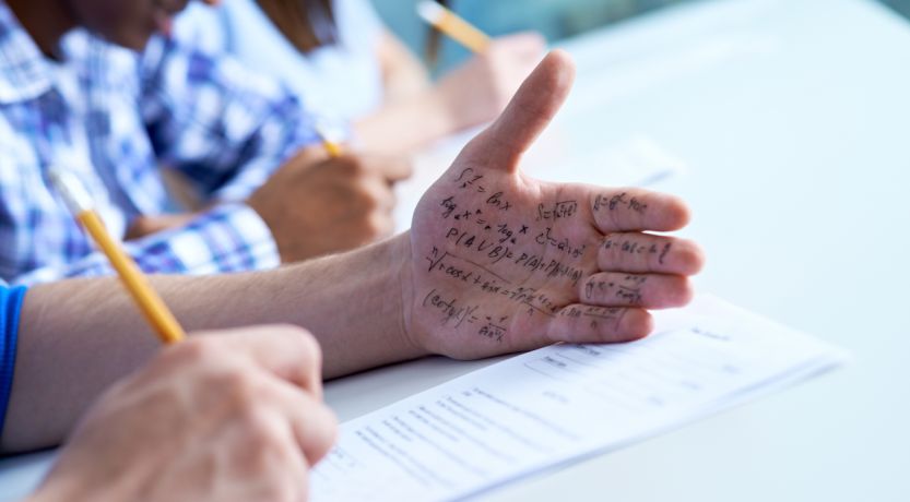 Photo of a test takers with cheat notes written on his hand, to illustrate the article What Does the Bible Say About Honesty and Integrity?