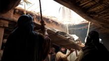 Photo illustration of a man being lowered through a roof to illustrate one of Jesus' healings, for the article What Can We Learn From Jesus’ Early Healings?