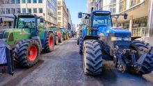 Photo of tractors on a city street as part of a protest, to illustrate the article, Why Farmers Are Protesting Around the World