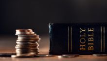 Photo of a stack of coins next to a Bible, to illustrate the article You Cannot Serve God and Money