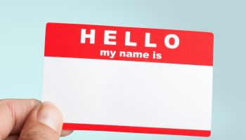 A photo of a blank name tag held by a hand. This illustrates the article 