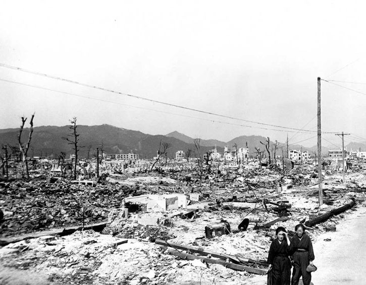 <p>A couple walks by decimated buildings in Hiroshima.</p>