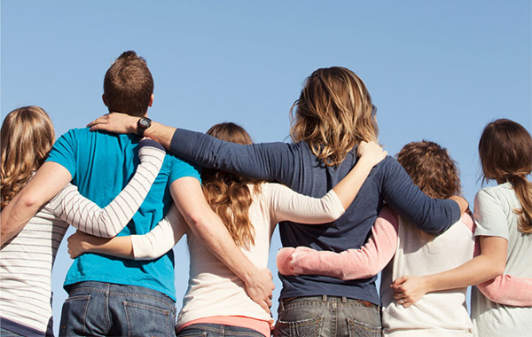 Group of young people arm-in-arm facing away