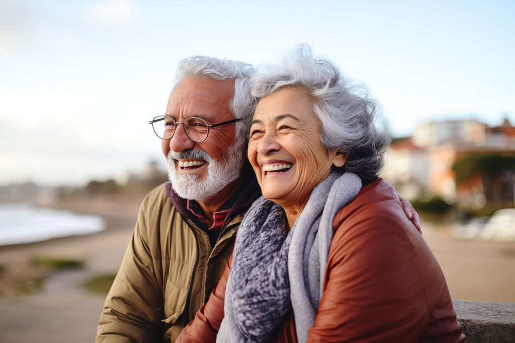 Happy, older couple sitting on the beach