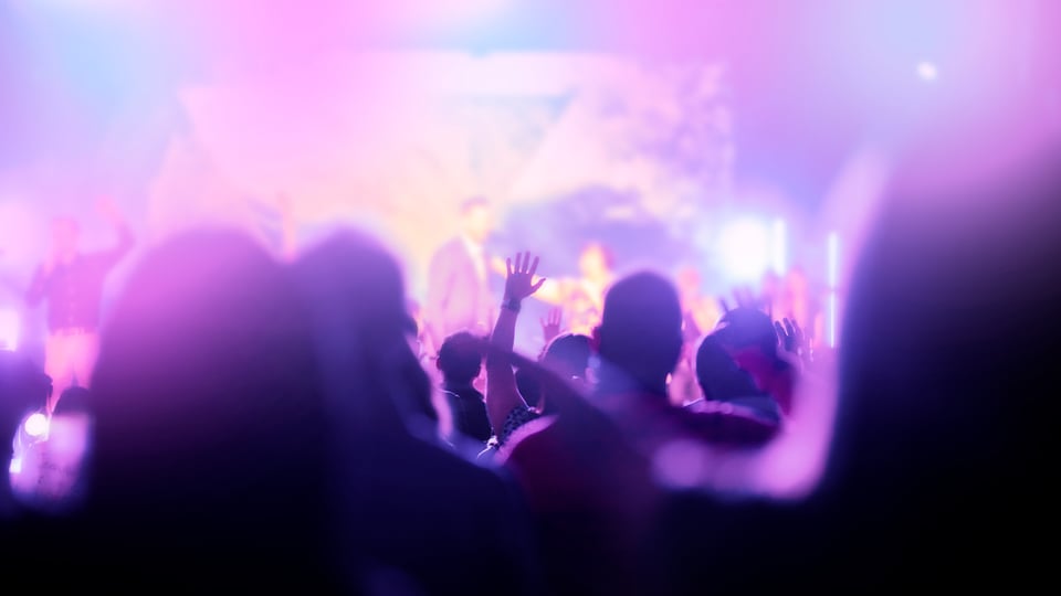 Colorful fuzzy photo of a modern evangelical worship service to illustrate the article 