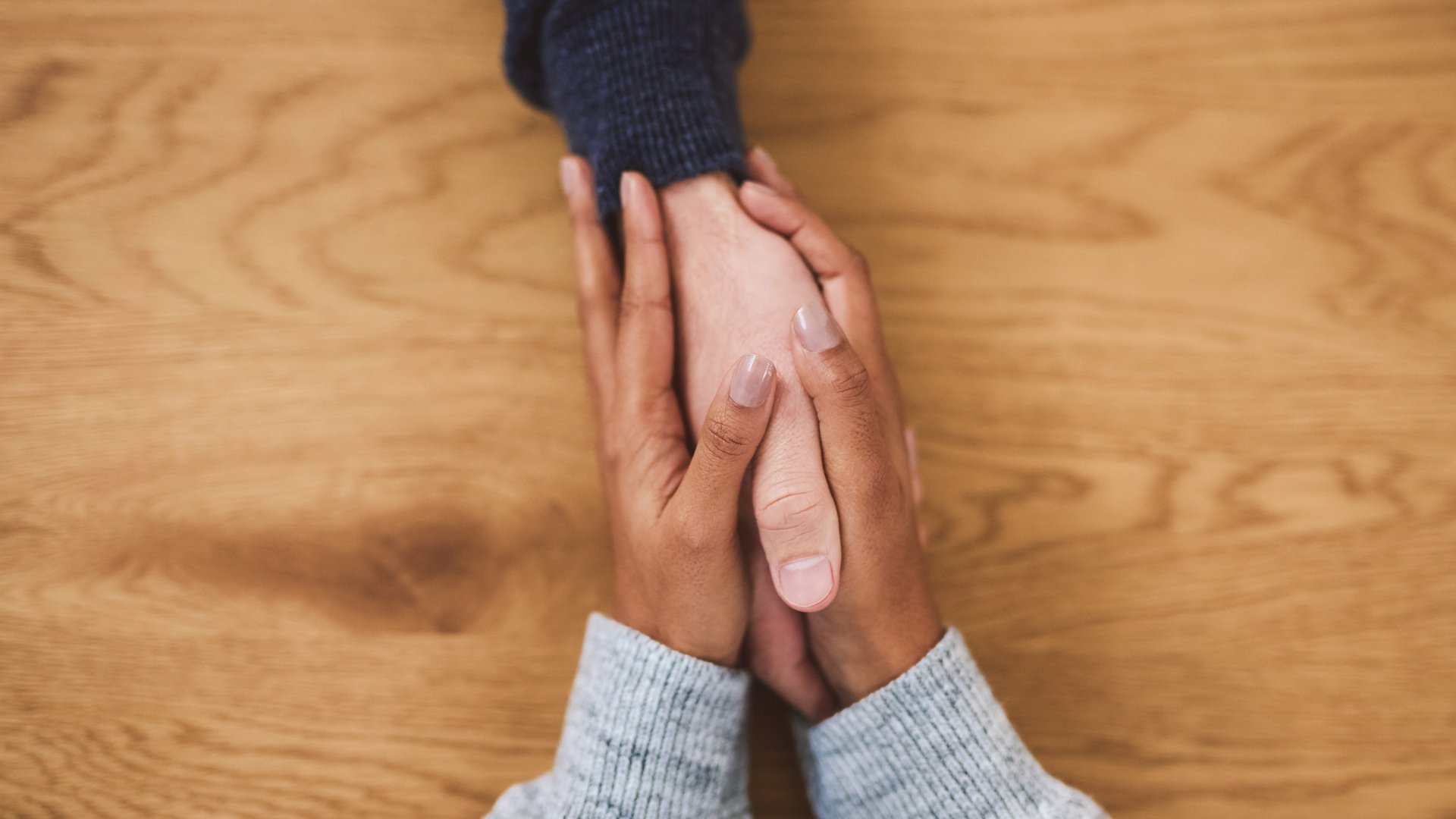 A person grasping another person's hand to illustrate the article Is Empathy a Sin?