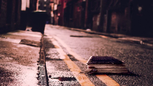 Photo of a Bible on a city street at night, to illustrate the article Truth Is Fallen in the Street