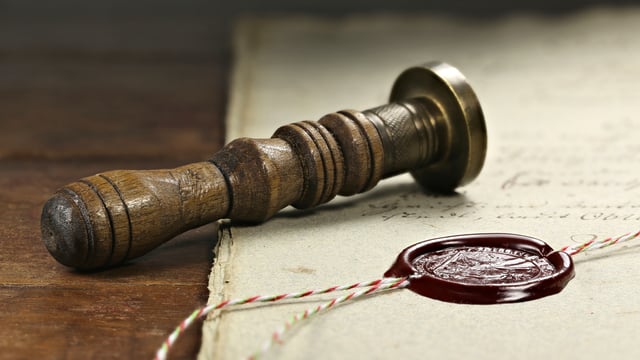 Photo of a seal laying beside a wax seal on a document to illustrate the article Sealed by God