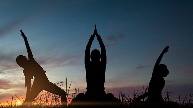 Photo of three people doing poses against an early morning sky to illustrate the article 
