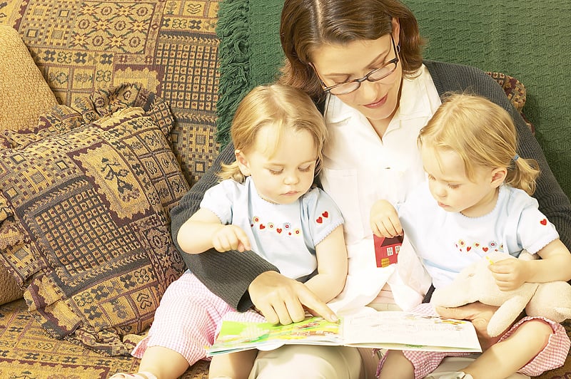 Reading for Ultimate Success; mom reading to two girls on her lap.