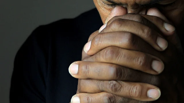 A man's clasped hands to illustrate Praying for Protection