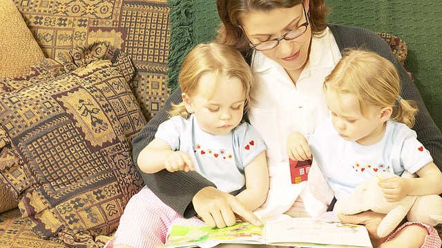 Reading for Ultimate Success; mom reading to two girls on her lap.