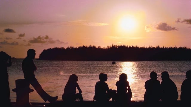 Relationships: group talking at a lake at sunset.